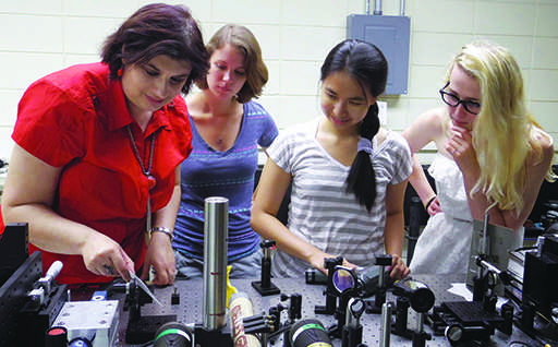 Associate Professor Madalina Furis, director of materials science, observes gear with with Alice Perrin from the College of William and Mary, Kim Hua and UVM senior Victoria Ainsworth. PHOTO COURTESY OF MADALINA FURIS
