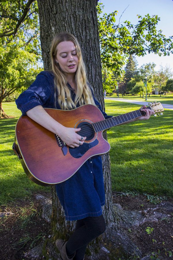 Senior Kristi Blow practices guitar on the Waterman green Oct. 18. Blow, a singer-songwriter, will be performing at Radio Bean Nov. 5.