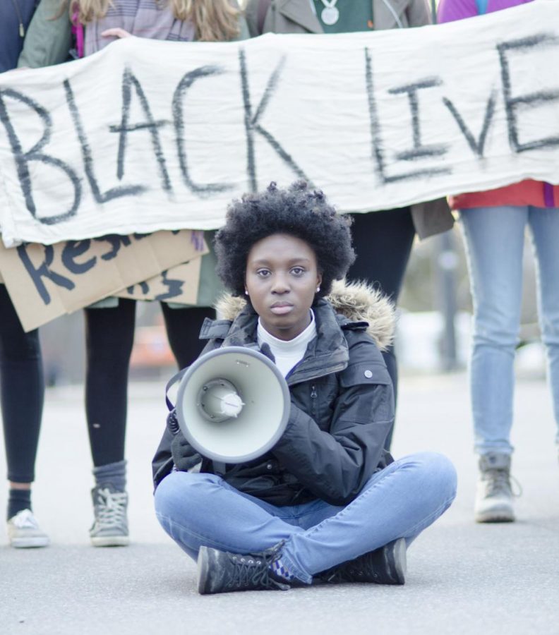 Sophomore BSU President Harmony Edosomwan sits in the middle of Main Street during the protest. 