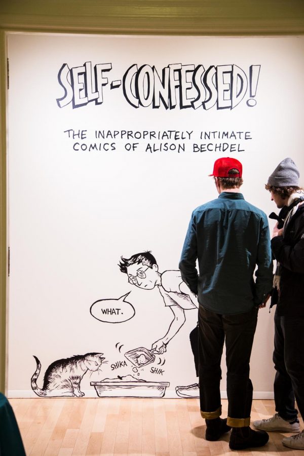 (Left) Two students admire a self portrait of Alison Bechdel hanging in the Fleming Museum. (Right) Alison Bechdel speaks at the opening of the Fleming exhibit featuring her work on Feb. 7.