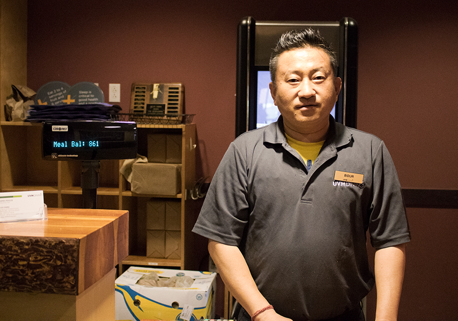 Bidur Rai stands at the front desk of Simpson Dining on Redstone Campus