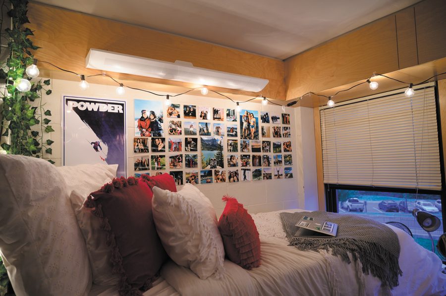 Photos of family and friends, a skiing poster and string lights decorate the wall of sophomore Chrissy Schultz’s dorm room, Sept. 23. Although she lives in a double, Schultz and her roommate don’t feel the need to match decoration styles.