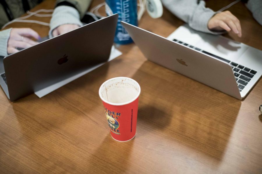 Students study with an empty coffee cup between them at 10:30 p.m. Nov. 19, in Howe Library. 