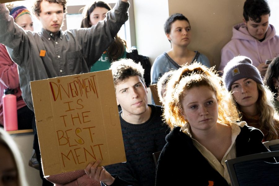 Junior Lowell Deschenes brandishes a sign reading "Divestment is the best investment."