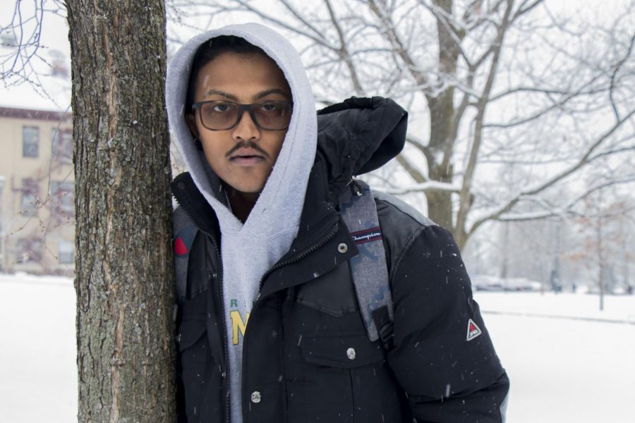 Senior Andrew “Ace” Trainor-Clark stands against a tree outside the Davis center, Feb. 6. Trainor-Clark’s music is produced by Burlington-based producer Rajit Sachdeva. 