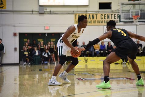 Junior guard Stef Smith moves to pass a University of Maryland Baltimore county defender during a game, Feb. 22. UVM lost the game 64-66.
