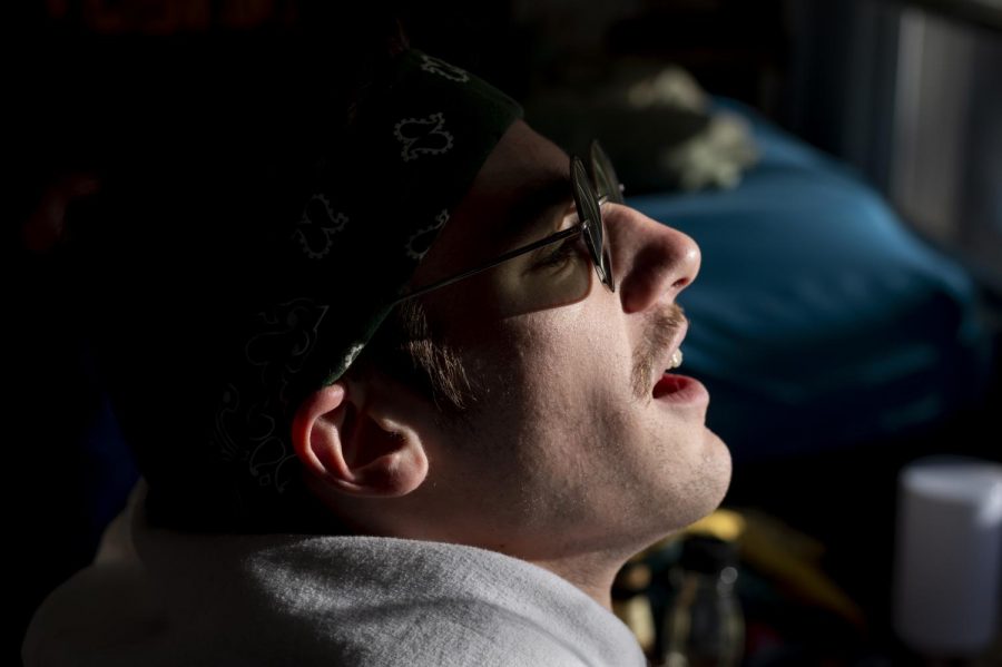 Hip-hop artist Cam Barnes soaks up sunlight during a recording session in his room in Sichel Hall, Feb. 28. A lot of the artists recordings are done here.