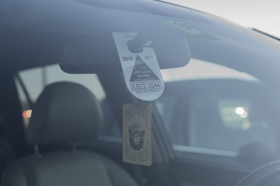  A UVM employee parking pass hangs from the rearview mirror of a car in Jeffords parking lot. Parking permits are assigned according to the workplace of the employee.
