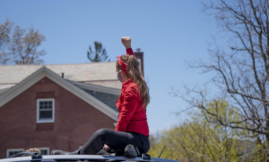 A protestor raises her fist in solidarity during a May 14, 2020 rally behind Waterman. Concerned UVM community members gathered to protest budget cuts academic departments could soon face. 