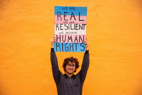 Alex Excaja-Heiss proudly holds up a poster he made for transgender rights July 15.