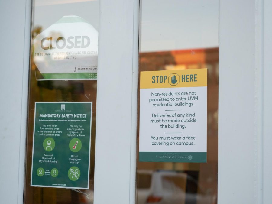 Signage on the door of a UVM residence hall reminds community members of the school's COVID-19 rules, including social distancing and the buildings' new no-guest policy.