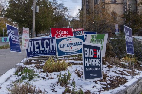 Campaign signs fill a patch of snow covered grass outside the Fletcher Free Library Nov. 3, where UVM Campus Democrats stood outside congratulating students for voting throughout the day.