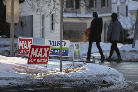 Campaign signs for Mayor Miro Weinberger and one of his challengers Max Tracy fill the patch of grass inside the roundabout intersecting Shelburne road and South Willard St. Feb. 5. 
