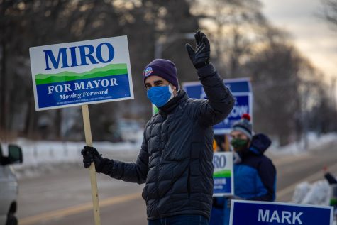 Burlington Mayoral incumbent Miro Weinberger stands on North Ave during a “honk and wave” with his supporters Feb. 19. As cars passed by they honked in support. 