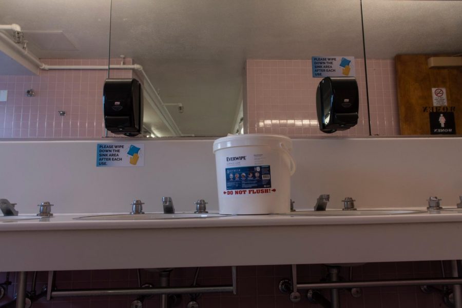 Decals in the women’s bathroom instruct students to use the provided wipes to wipe down the sink counter after every use inside of Jeanne Mance.