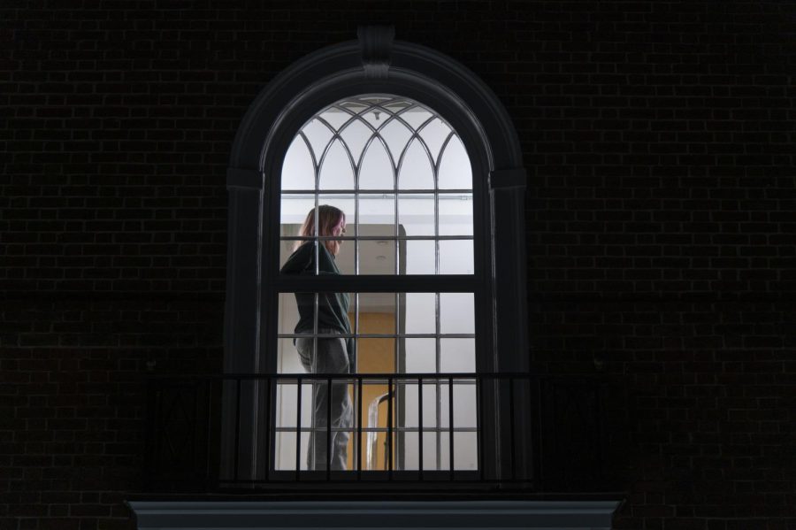 Ella Ruehsen, a UVM sophomore and assistant news editor for the Cynic stands at the center window of Slade Hall Feb. 13. Slade Hall is a residence hall on Redstone Campus which has been reserved for COVID positive students. 