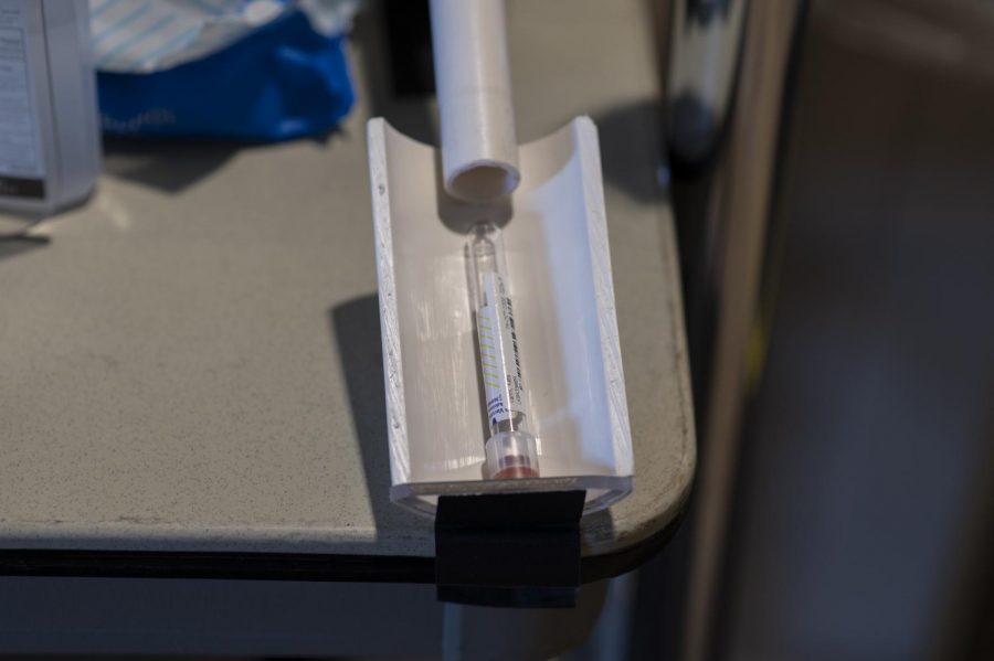 A testing vial sits in a makeshift distribution pipe at UVM's COVID-19 testing site.