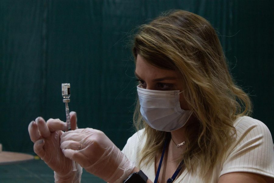 A Walgreens employee fills a syringe with the Johnson and Johnson vaccine in the Patrick Gym May 2.