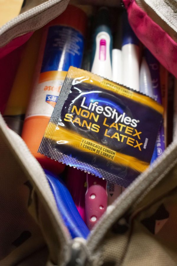 A condom from Living Well in the Davis Center pictured with school supplies Dec. 3.