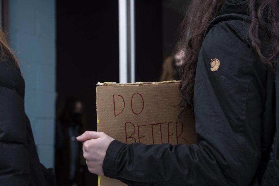 A student holds a cardboard sign stating “Do better,” Feb. 18.
