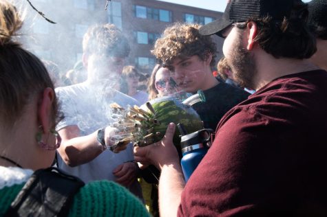 Students crowd around a bong made out of a watermelon on the Redstone green.