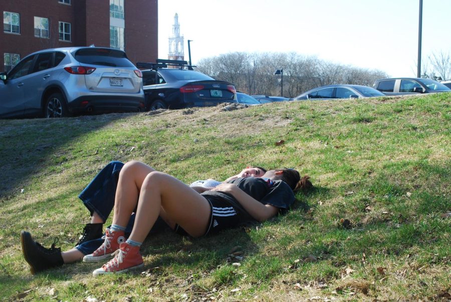 Photo Illustration: A couple laying on campus grass. Some students are distressed with public displays of affection on campus.
