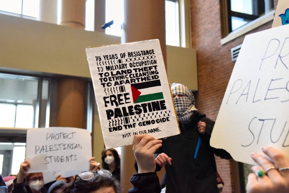 Students raise their signs in protest in the Davis Center Atrium Nov. 29.