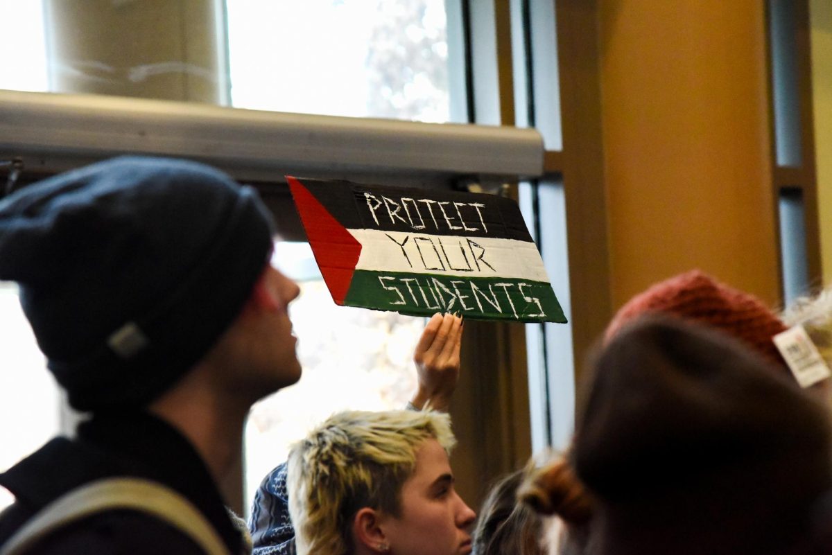 Students raise their signs in protest in the Davis Center Atrium Nov. 29