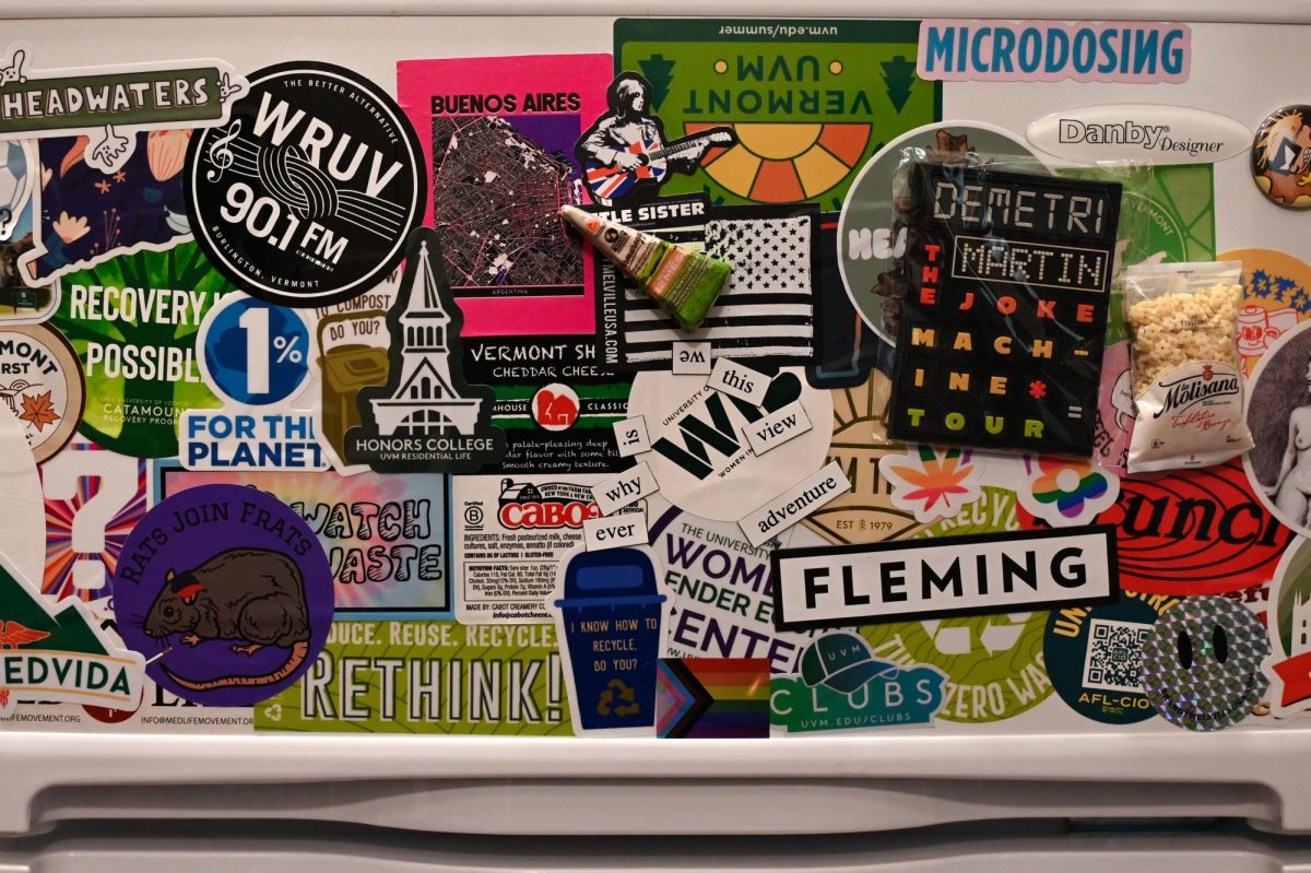 A dorm mini fridge covered in various stickers and magnets