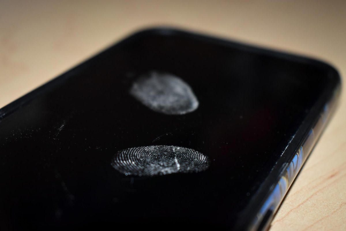 Photo Illustration: A fingerprint on a phone screen. 