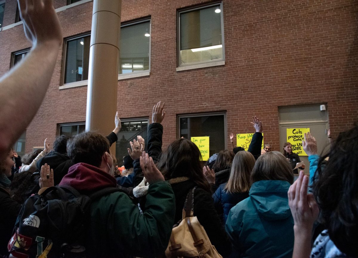 The crowd raises their hands in protest.
