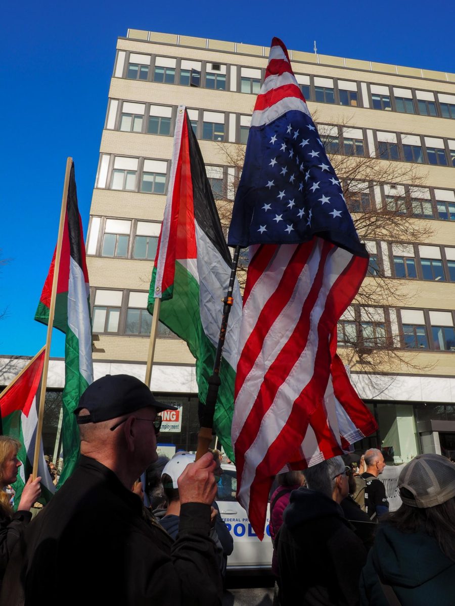 A man holds an upside down American flag outside the courthouse. 
